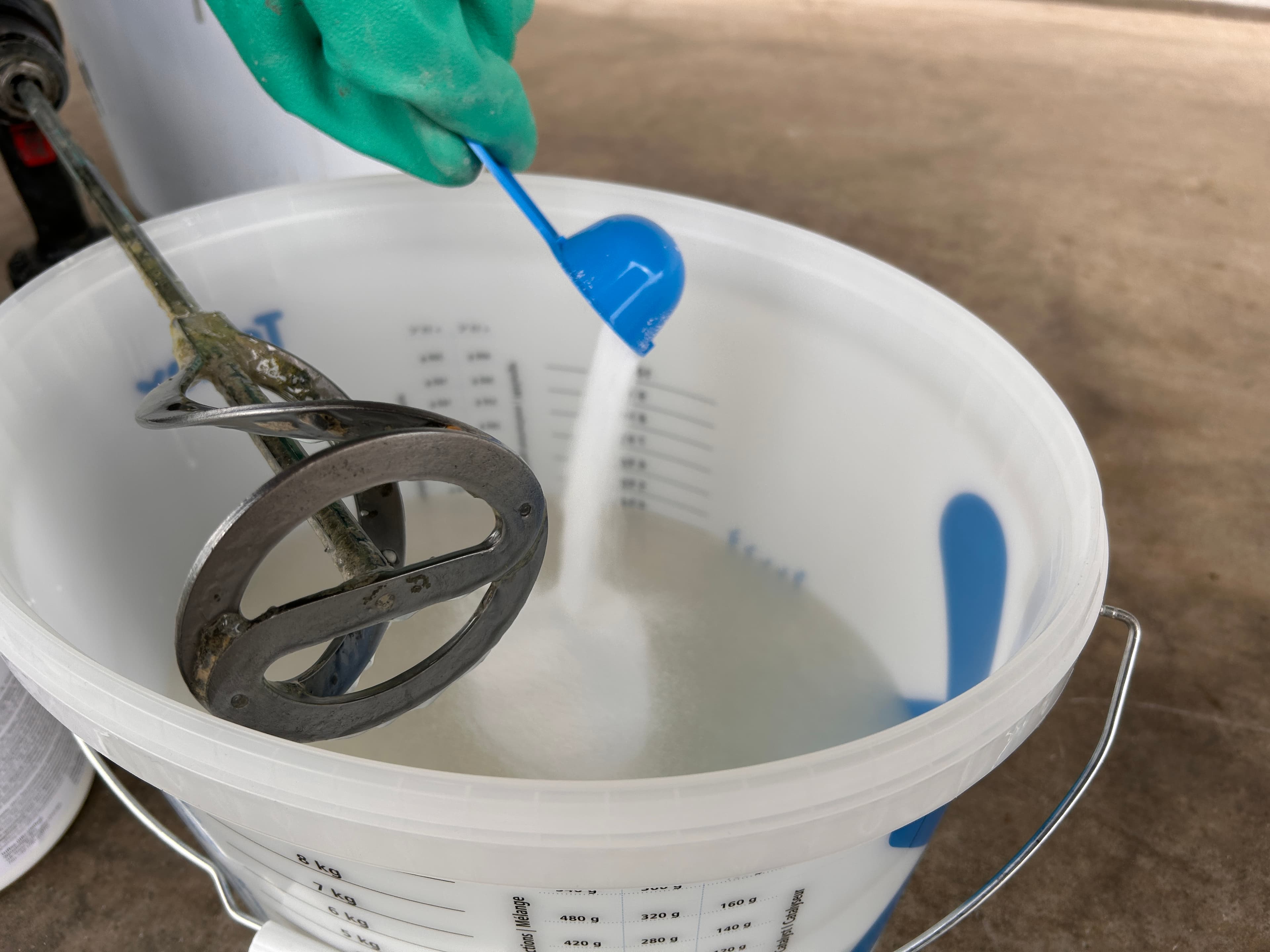 The powdered component is added to a bucket equipped with a mixer for blending