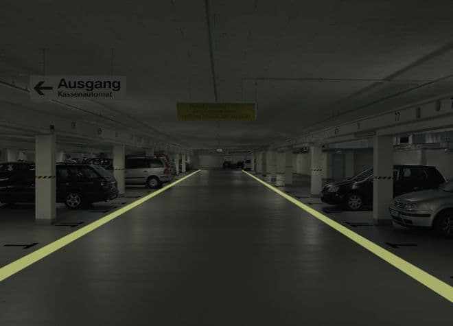 Tiefgarage mit beschichtetem Fahrbahnboden und markierten Fahrspuren im Parkhaus, langlebige Bodenbeschichtung für Parkbauten