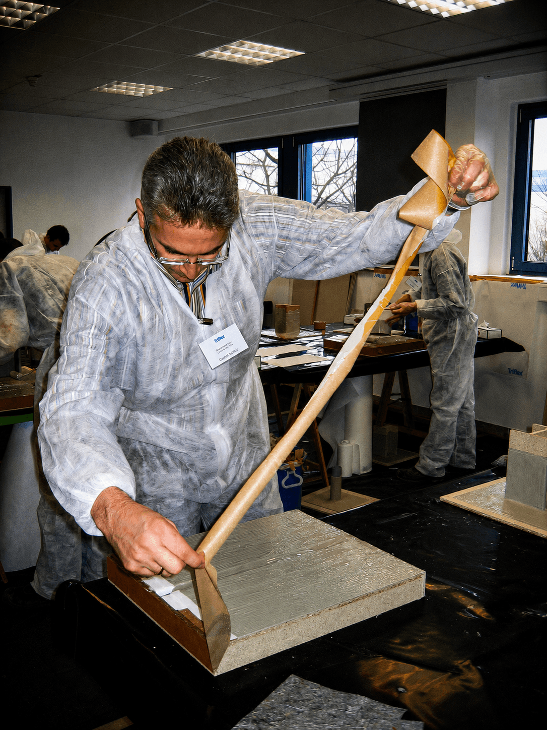 Verarbeiter bringt im Praxisseminar Triflex Material am Modell auf und trainiert die praktische Ausführung einer Abdichtungs- oder Beschichtungsaufgabe.