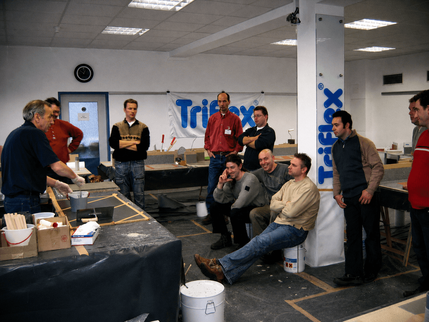 Teilnehmer verfolgen im Praxisseminar eine praktische Vorführung am Modell und tauschen sich zur Verarbeitung von Triflex Systemen aus.