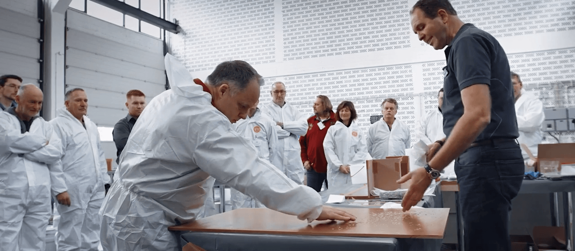 Praktische Schulungssituation mit Teilnehmern bei der Verarbeitung von Materialien in einer modernen Trainingshalle