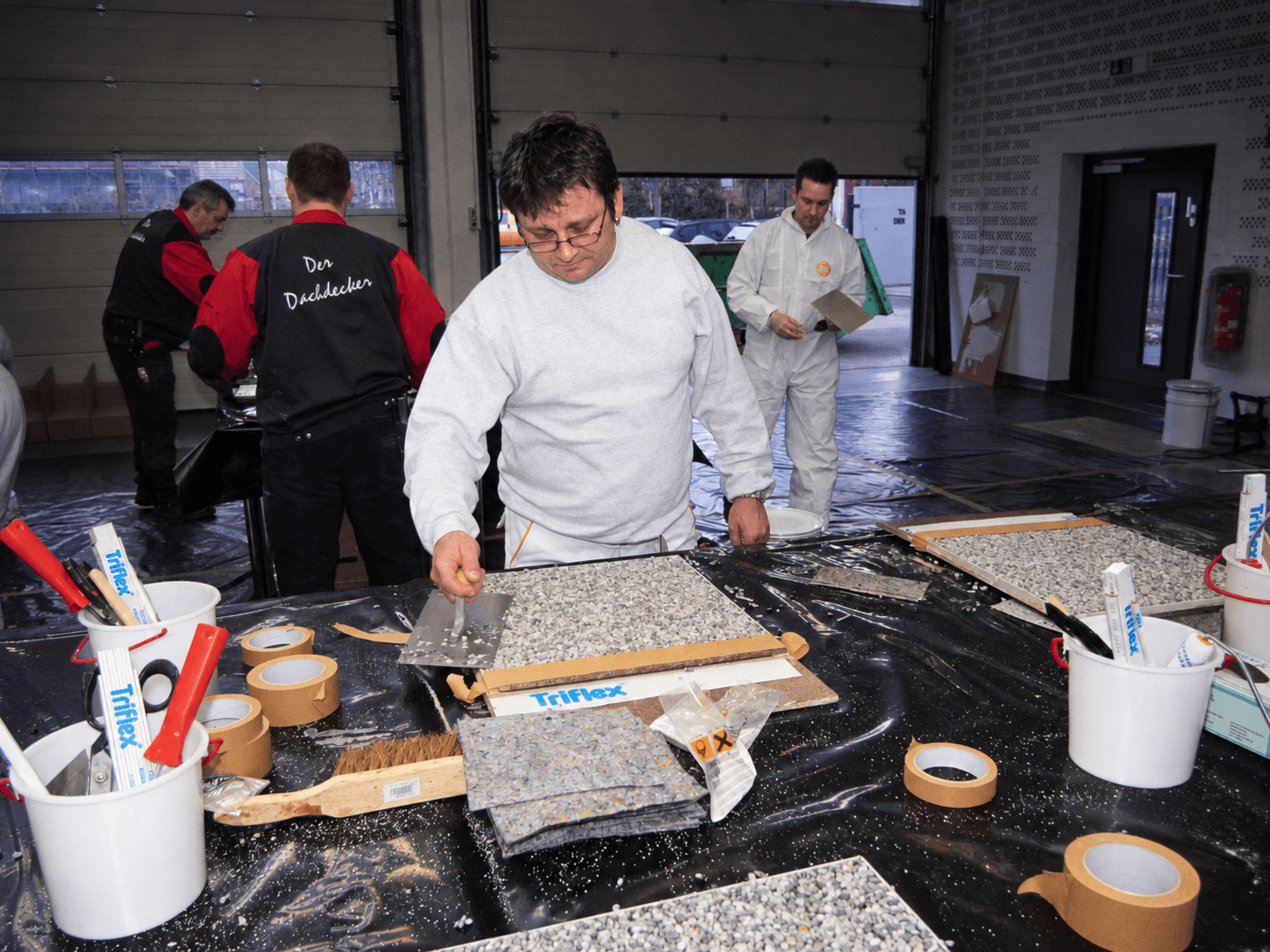 Verarbeiter arbeitet im Praxisseminar an einem Modell mit Oberflächengestaltung und übt die Verarbeitung von Triflex Materialien.