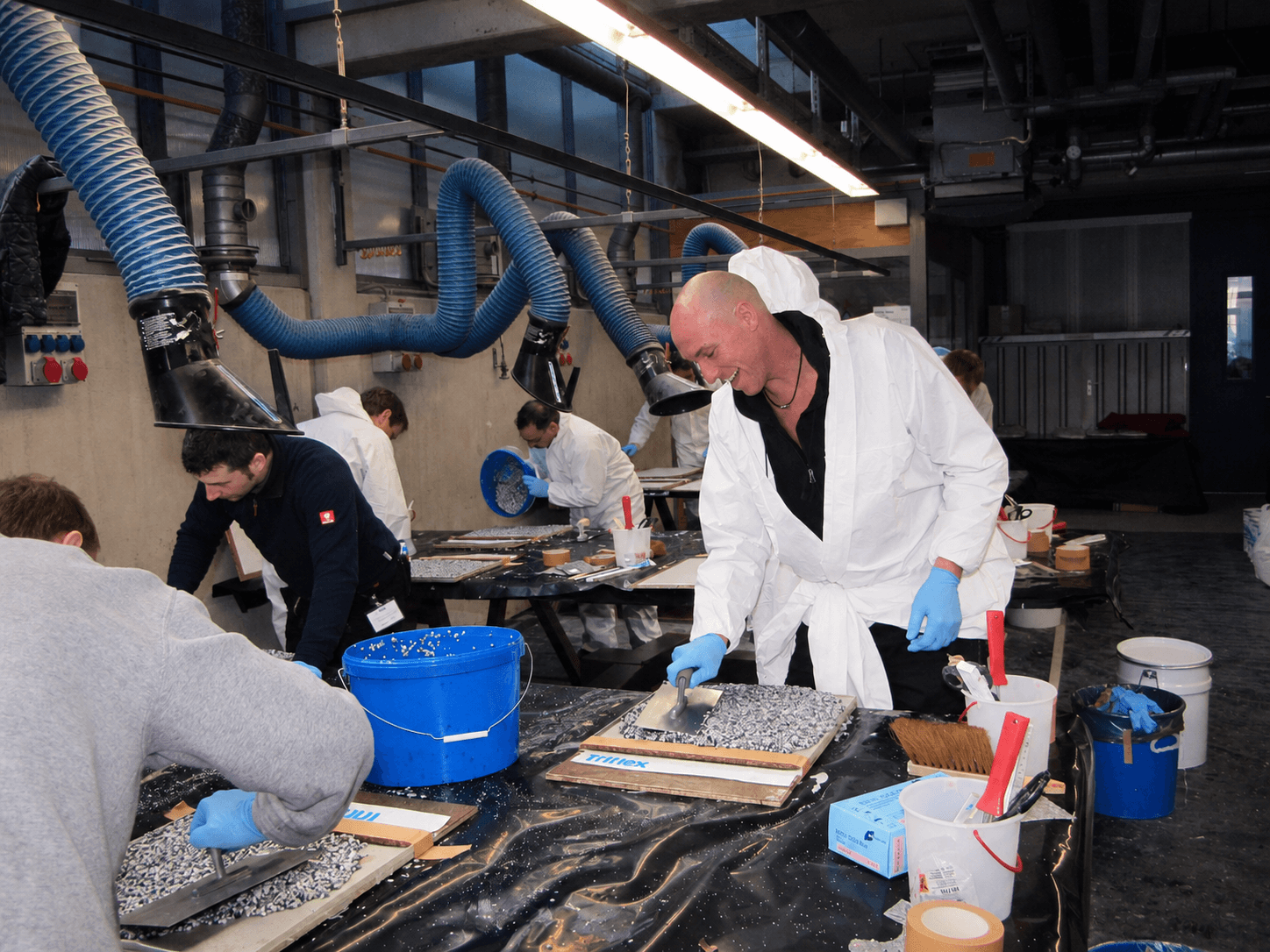 Teilnehmer arbeiten im Praxisseminar gemeinsam an Modellen und üben praktische Verarbeitungsschritte mit Triflex Materialien.