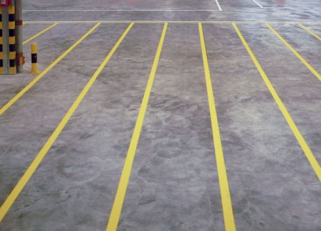 Gelbe Bodenmarkierungen aus Preco Line EP 2K zur Verkehrs- und Sicherheitskennzeichnung in einer Industriehalle