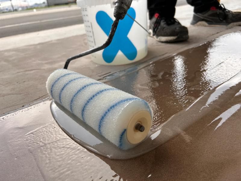 Rolle mit Triflex Cryl UniPrimer 285 auf mineralischem Untergrund in Nahaufnahme