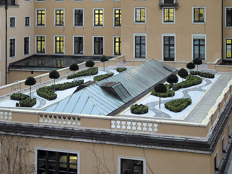 Begehbare Dachbegrünung mit integrierter Rooftop-Terrasse, Wegen und technischen Aufbauten auf einem innerstädtischen Flachdach.
