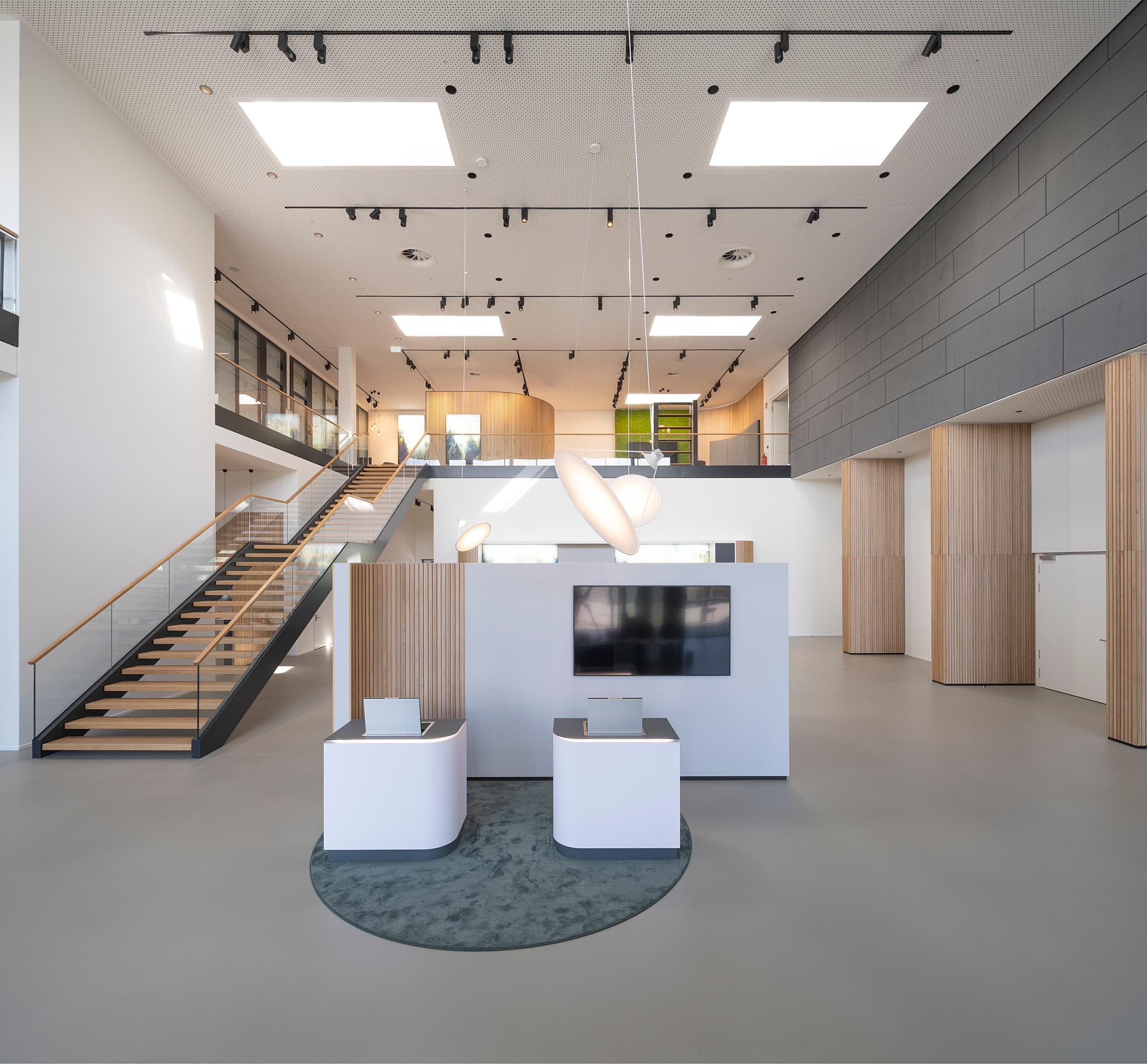 A modern interior design for a commercial building featuring an open reception area, a gallery level, and clean lines