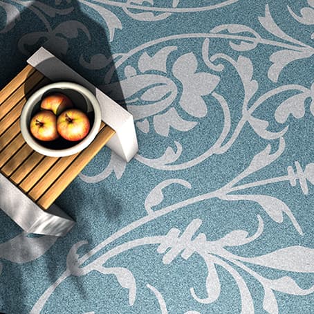 Dekorativer Bodenbelag mit floralen Ornamenten im Triflex Creative Design, dekorativ inszeniert mit Tablett und Äpfeln