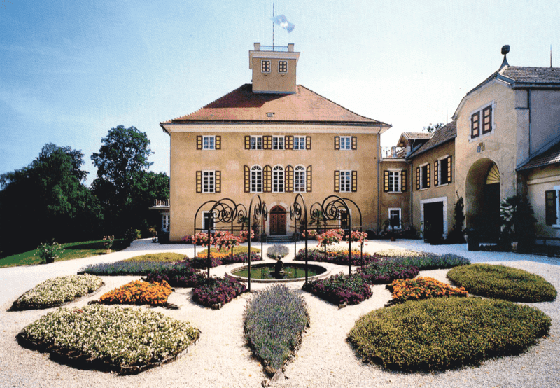 Historisches Schlossgebäude mit symmetrischer Gartenanlage und gepflegten Beeten – denkmalgeschützte Architektur mit barocker Gestaltung in Deutschland.