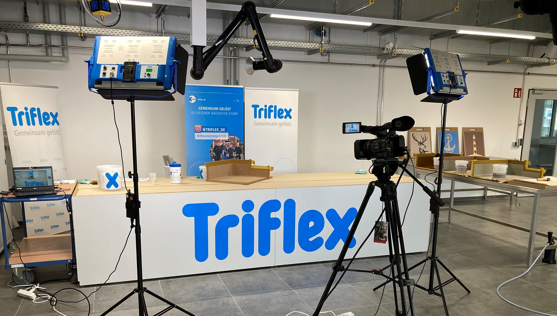 Film set with camera, lighting equipment, and Triflex branding in a training environment