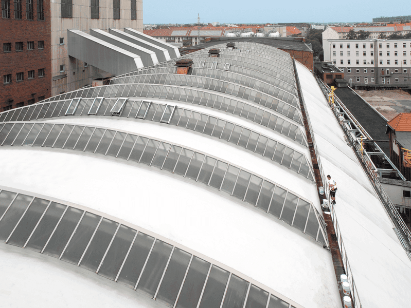 Gewölbtes Industriedach mit Lichtbandkonstruktion und großflächiger Dachgeometrie